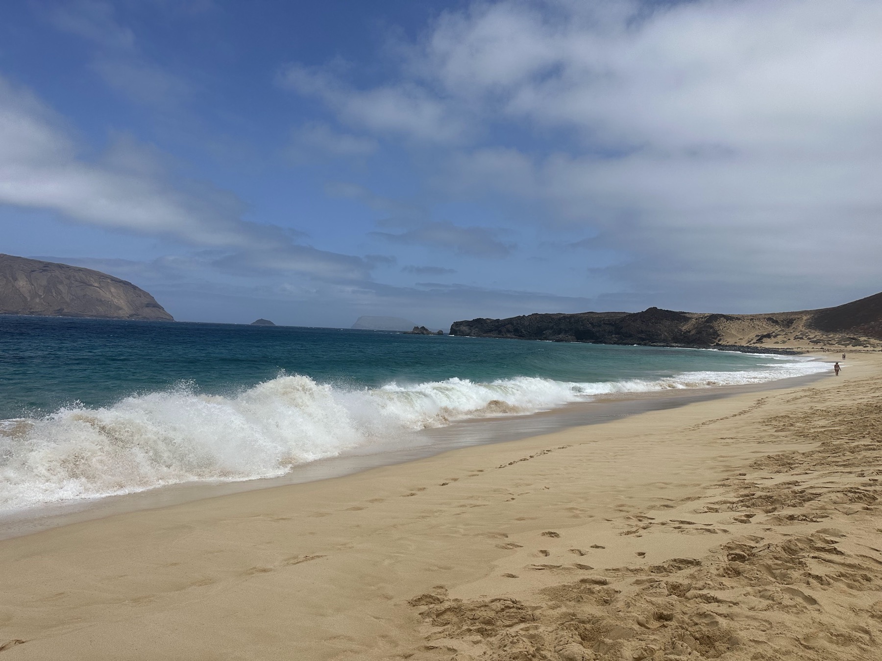 Playa abierta con oleaje y paisaje claro en La Graciosa
